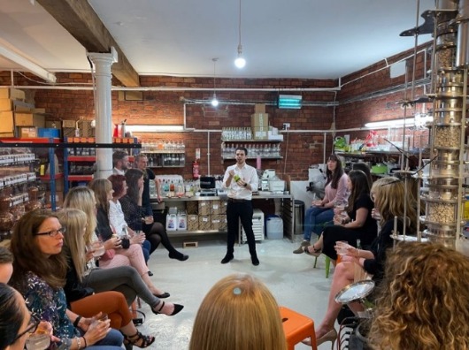 Group instructor leading a learning sessions at a gin tasting networking event at a distillery