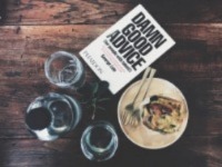 An overview of a table with glasses, a plate and a book placed on top