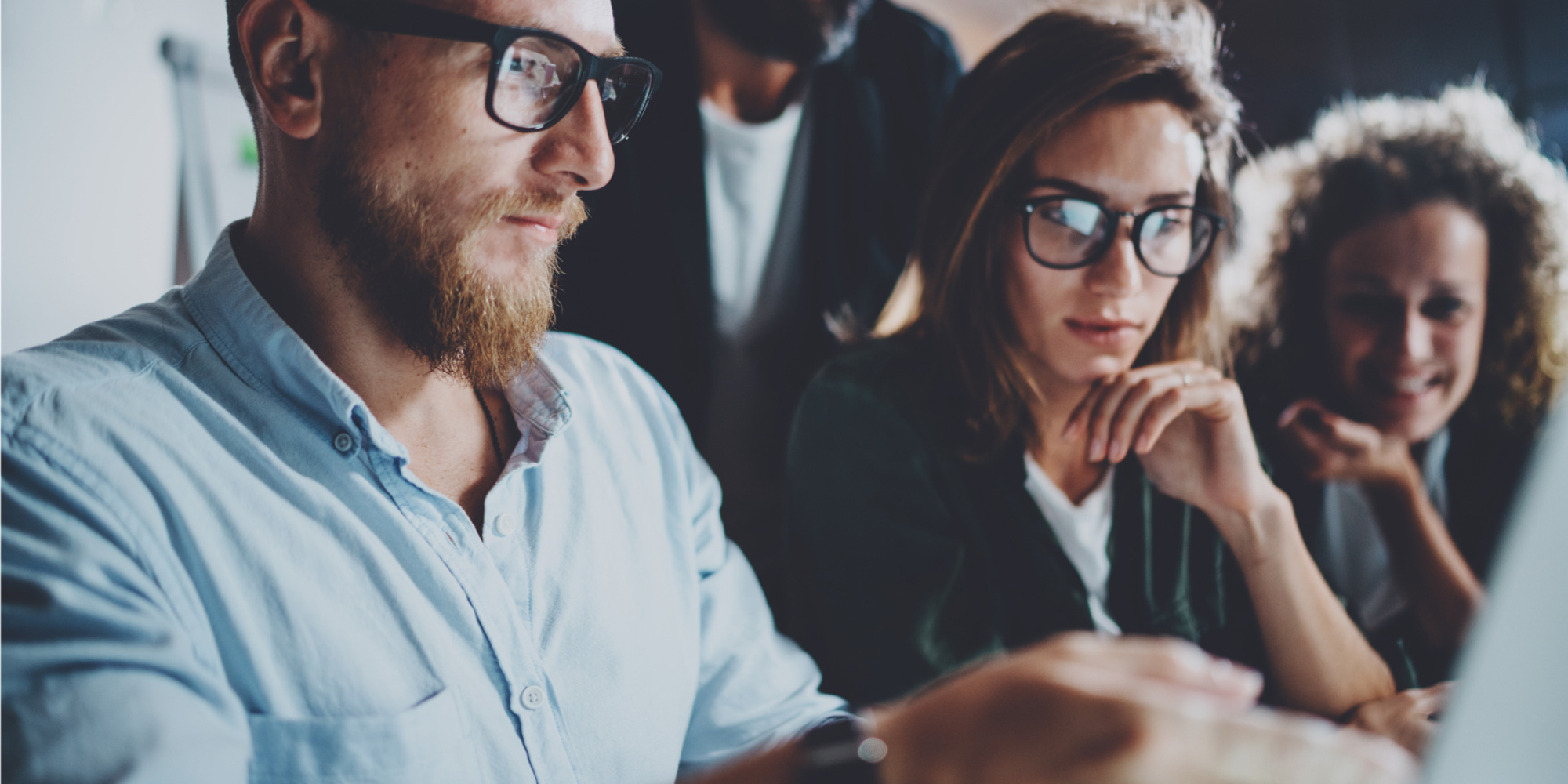 Three finance and accountancy colleagues work together in an office