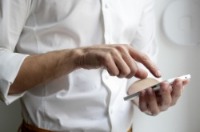 A close up view of a person in a white shirt using a calculator