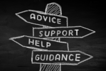A chalkboard displaying signs that read "advice," "support," "guidance," and "help," emphasising employer assistance.