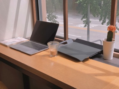 A laptop and a cup of coffee on a desk, creating a cozy work-from-home setup.