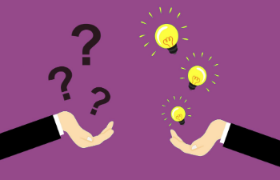 Two people seated at a table in an office, engaged in a job interview discussion.