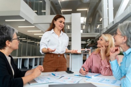 A finance and accountancy leader discusses strategies with colleagues in a modern office setting.
