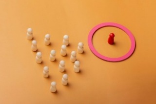Several figures standing around a red circle, collaborating on strategies for attracting new staff members.