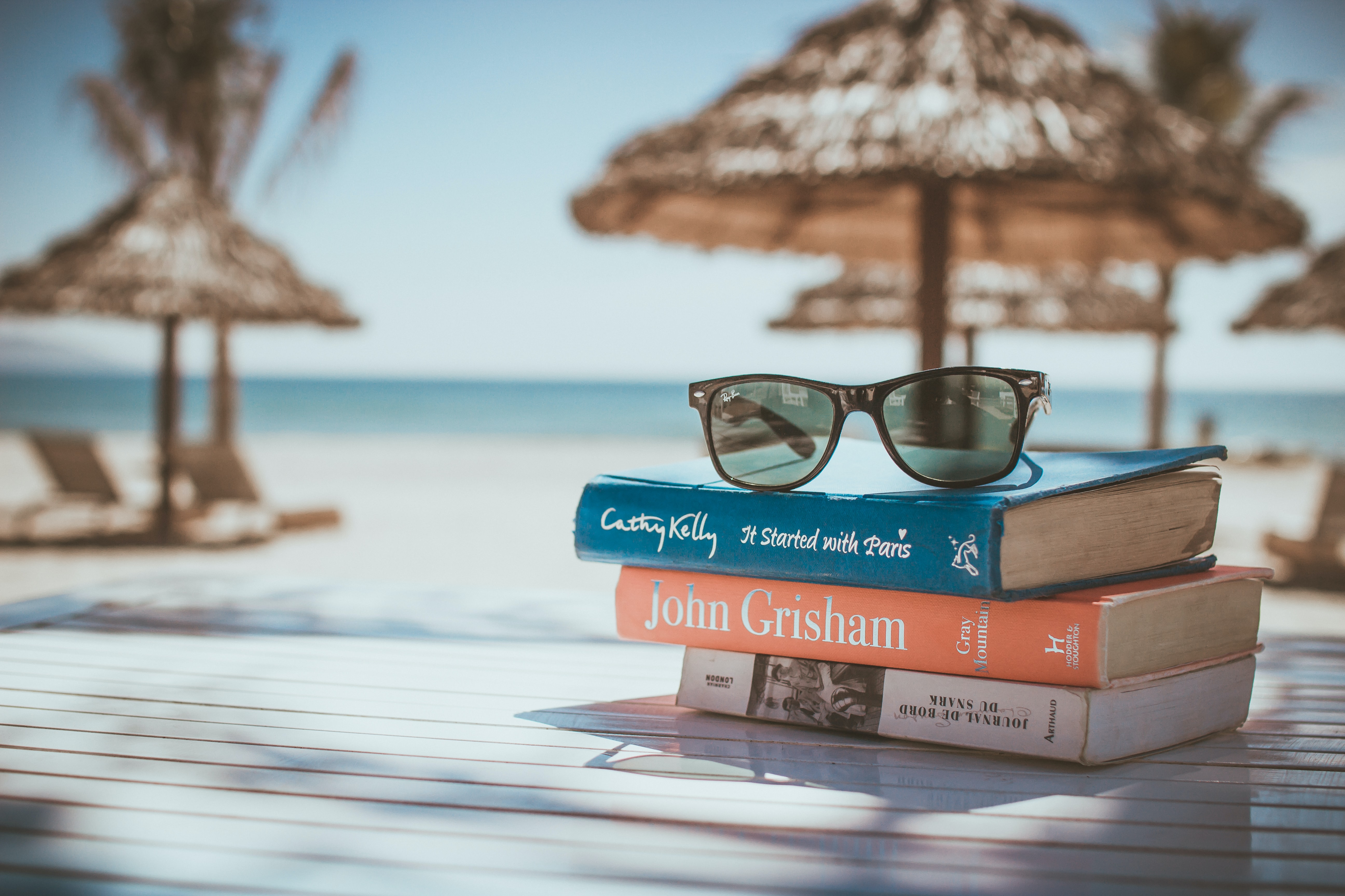 A beach scene featuring books, sunglasses, and an umbrella, symbolising relaxation for accountants boosting their online presence.