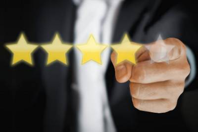 A man in a suit points at five star rating icons, symbolizing a strong business reputation and employee satisfaction.