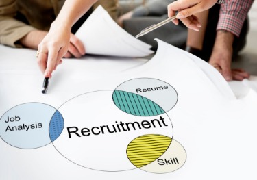 A group of people examines a recruitment diagram highlighting the slow recruitment process.