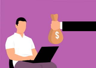 A man sitting on a chair with a laptop, researching expected salaries, next to a bag of money.