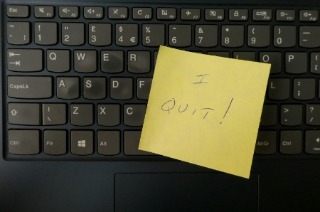 A close-up of a laptop keyboard featuring a handwritten "I quit" note, representing a resignation or career change.