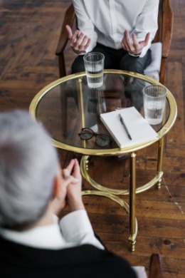 A man and woman at a table, discussing finance strategies and sharing advice in a professional setting.