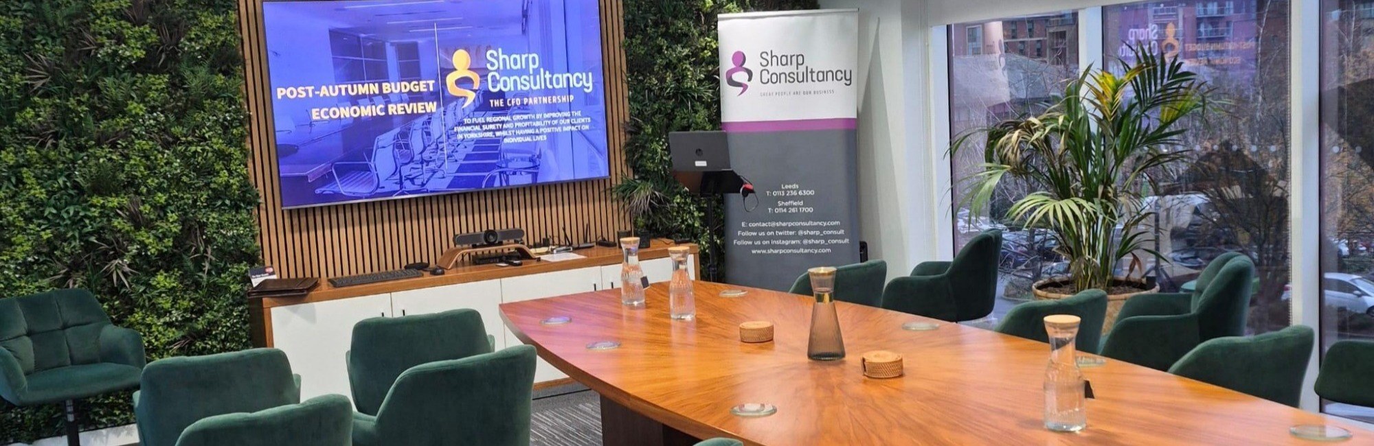 A spacious conference room featuring a large table surrounded by several chairs, ready for a meeting.