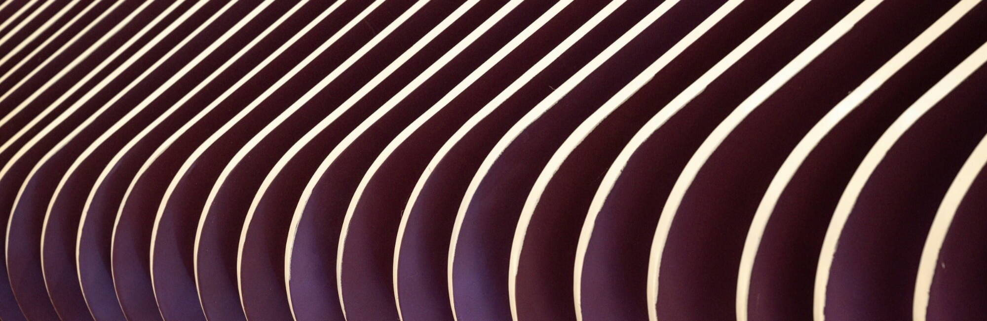 Close-up of a textured wall featuring smooth, flowing curved lines in a subtle color palette.