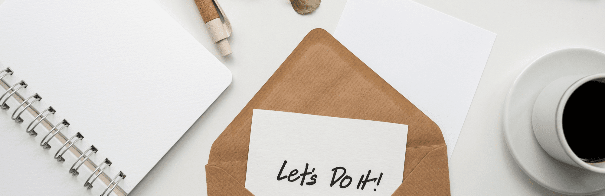 Image of an envelope, coffee cup, pen, and notebook on a white table, illustrating the idea of an enticing job offer.