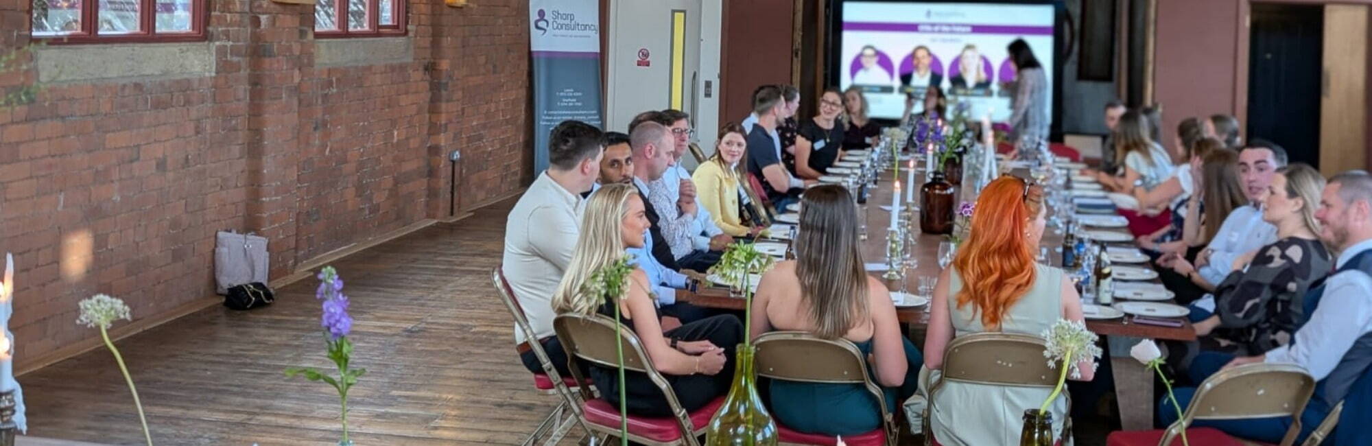 Attendees engaged in discussion at Sharp Consultancy's networking event for future CFOs, seated around a table.