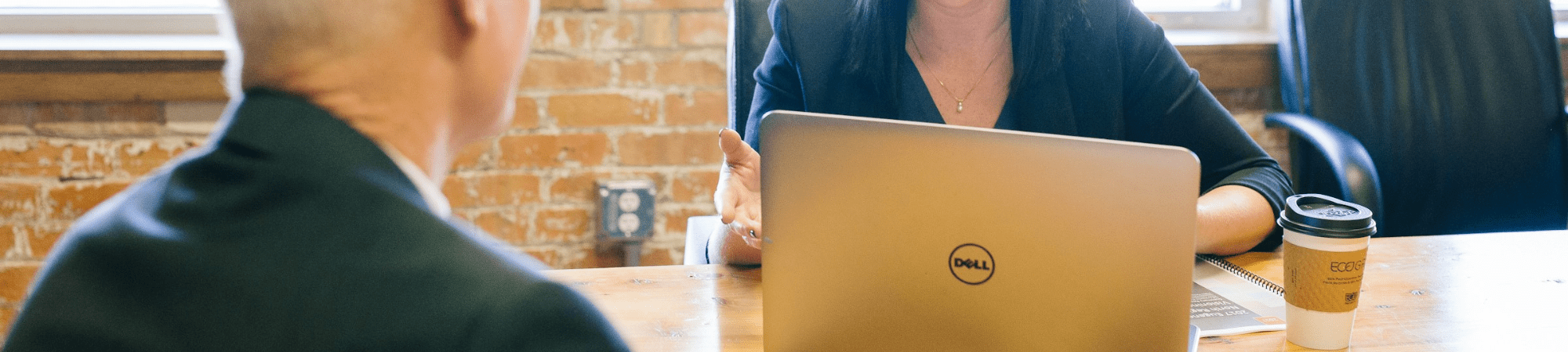 A woman at a desk with a laptop, conducting an interview for an accountancy and finance role.