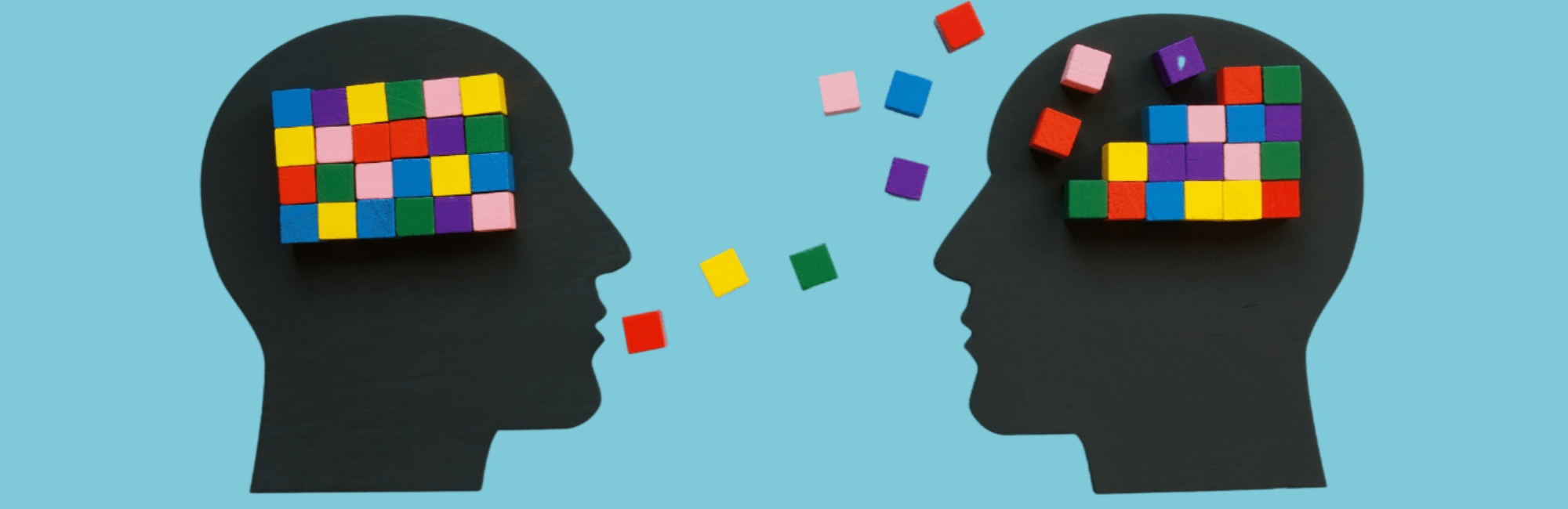 Two heads adorned with vibrant paper cutouts, symbolising creativity and mentoring in a collaborative environment.