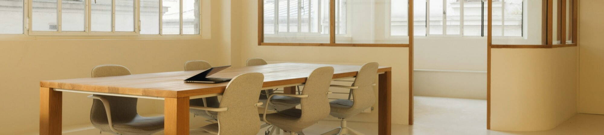 A wooden table surrounded by four chairs in a well-lit dining area.
